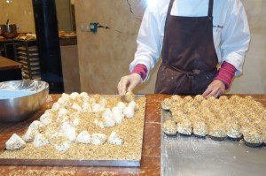 "Merveilleux" being rolled in nuts at Aux Merveilleux de Fred